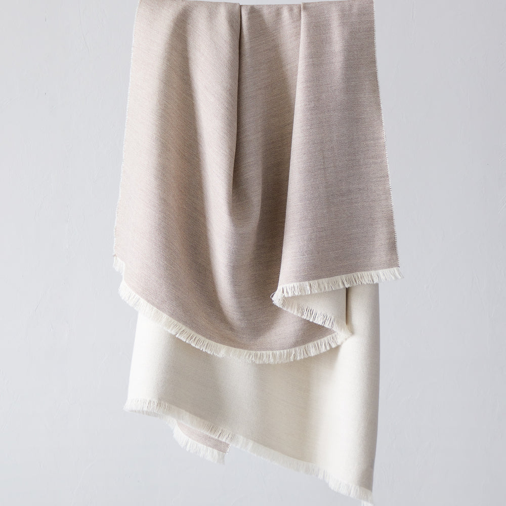 
                  
                    Fairkind Soñando sand alpaca throw blanket beige tan base with white back and fringe by Fairkind.
                  
                